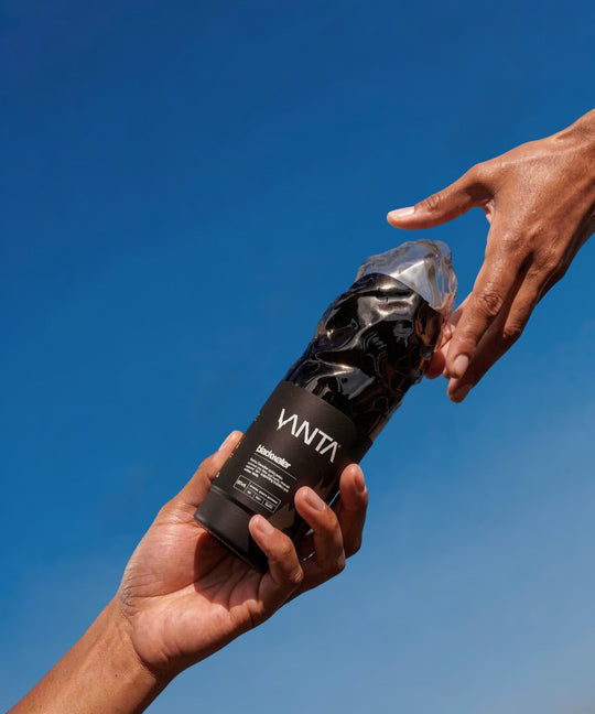 Two hands reaching towards each other with a Vanta product against a blue sky.